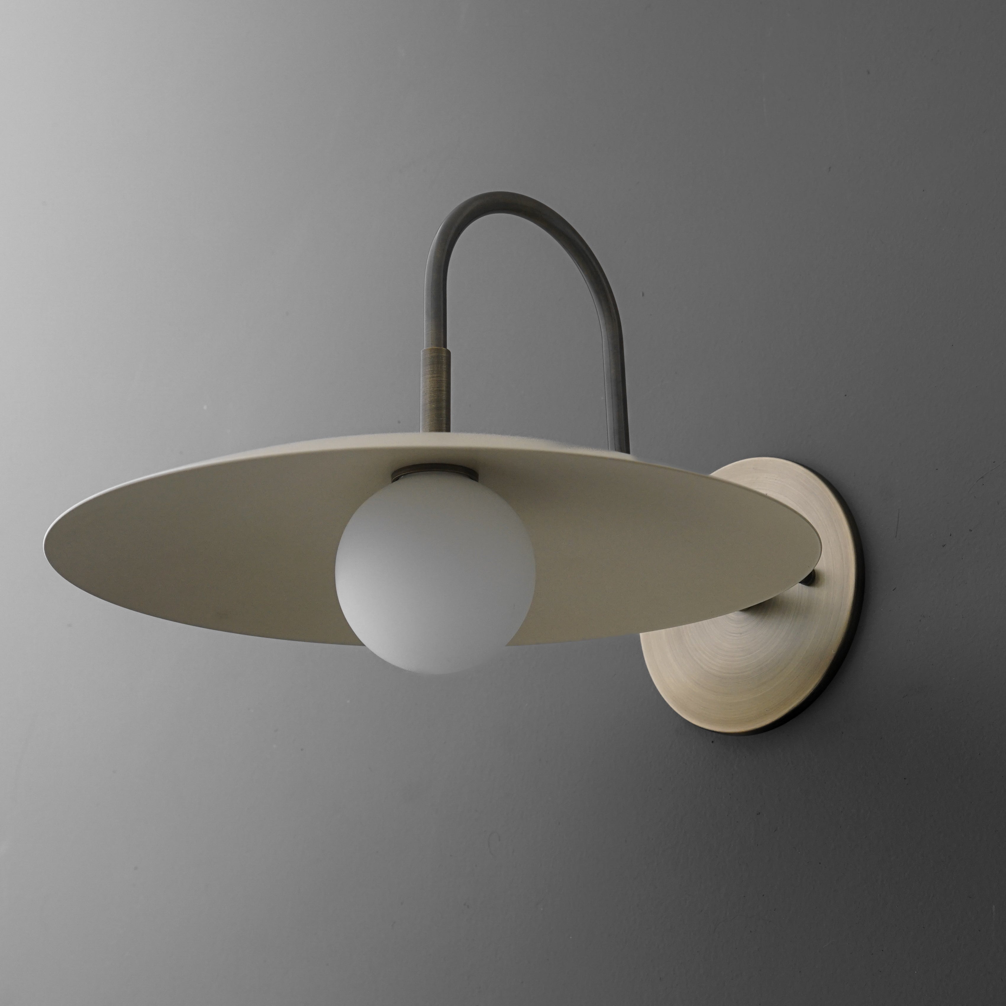 Curva Metal Modern Wall Sconce - Antique Brass Arm with Cream Disc Shade