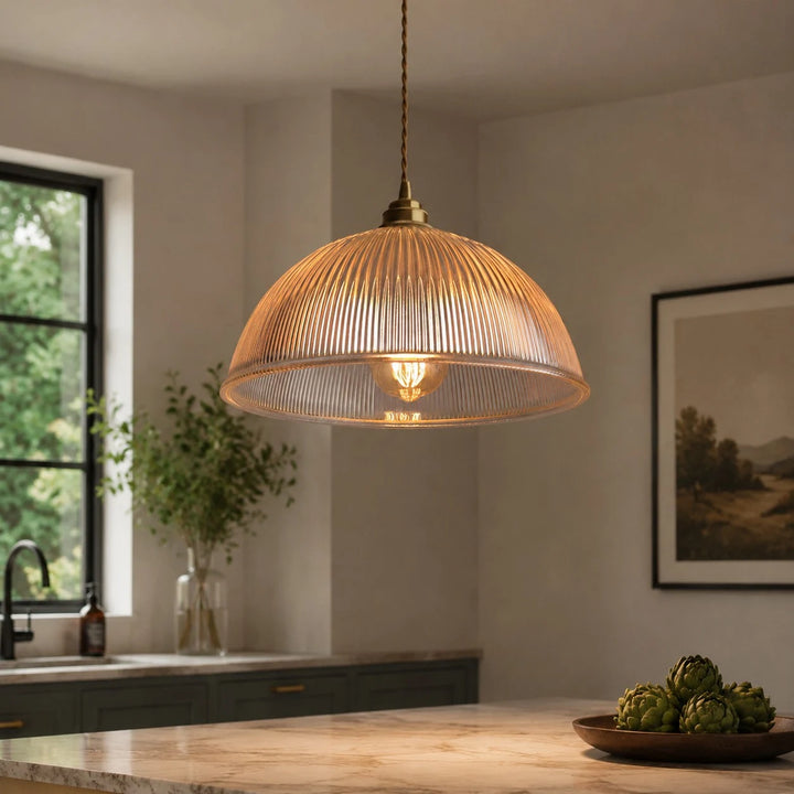 Clear ribbed glass pendant light glowing in a warm kitchen scene