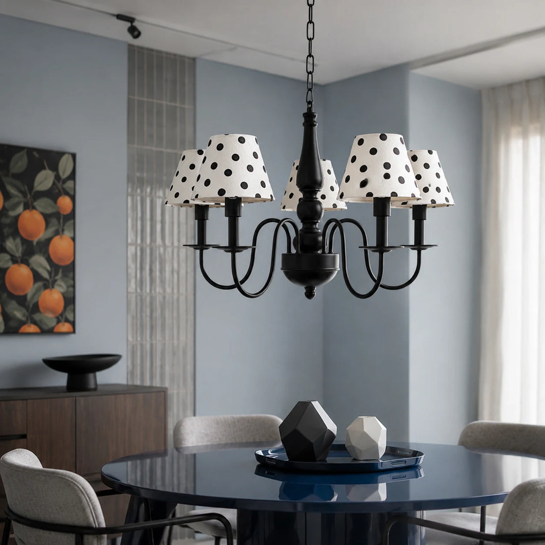 Black polka dot chandelier above a modern dining table