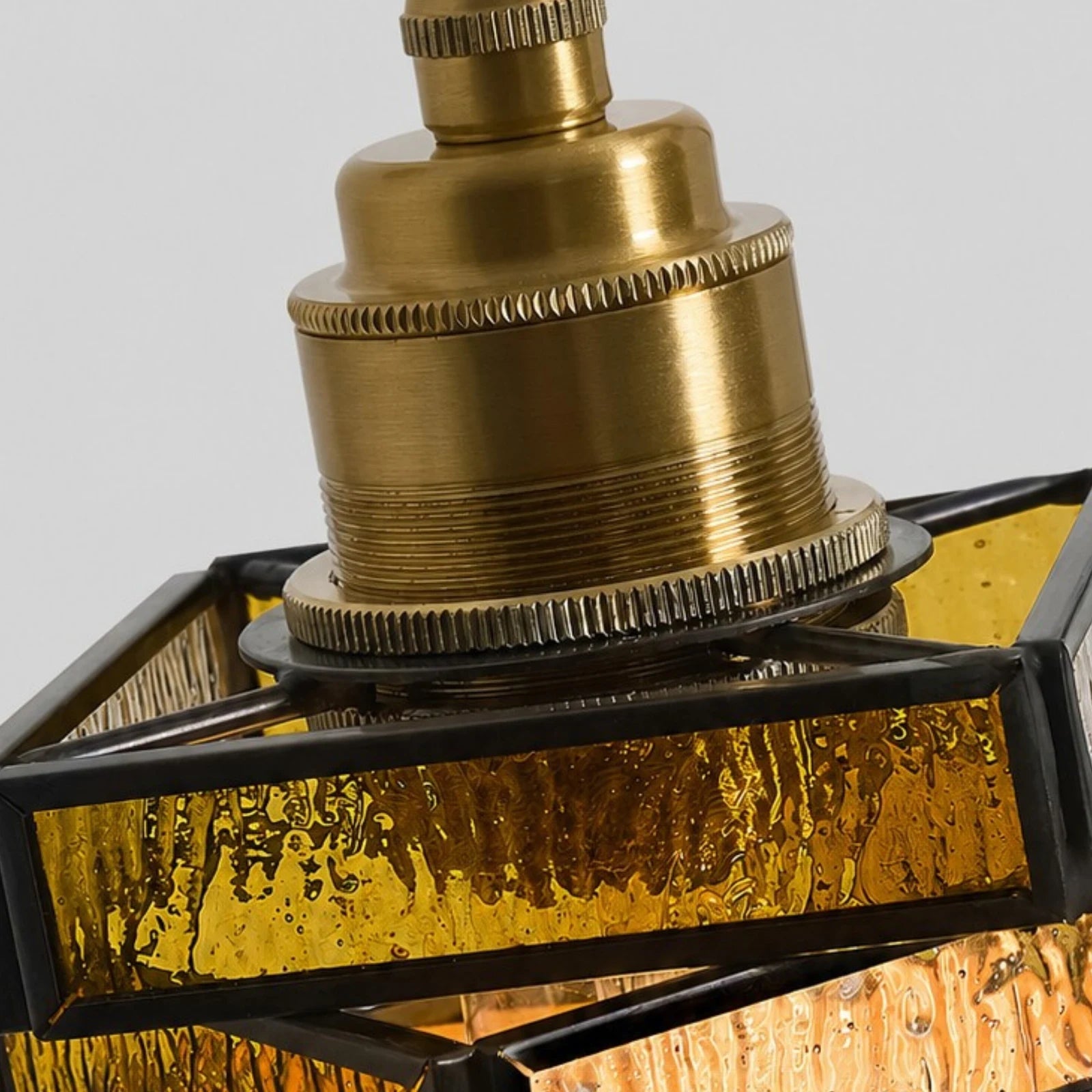 Brass-tone socket and stained glass frame detail