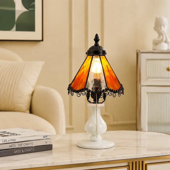 Orange stained glass table lamp styled on a bedside table in a cream bedroom