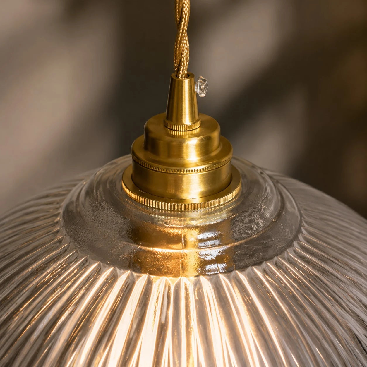 Brass cap and ribbed glass detail of the pendant light