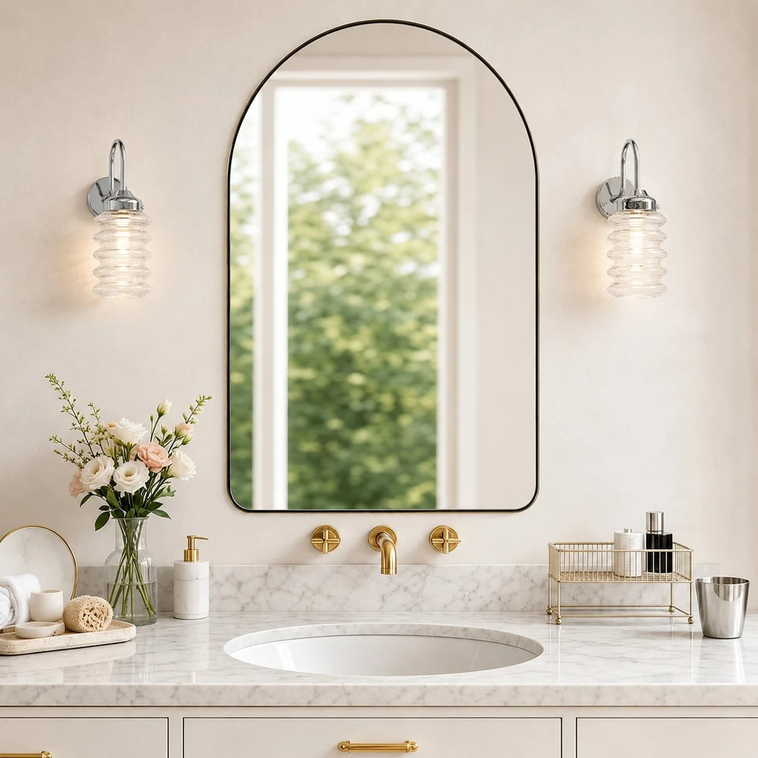 Pair of chrome ribbed glass wall sconces around an arched bathroom mirror