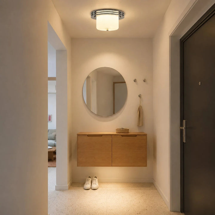 Chrome and milky white flush mount ceiling fixture installed in a compact entry area