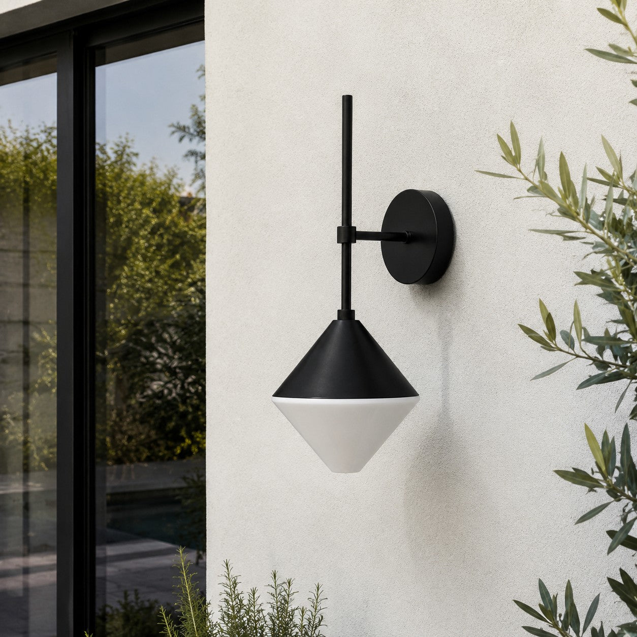 black and white outdoor wall sconce mounted on a garden exterior wall