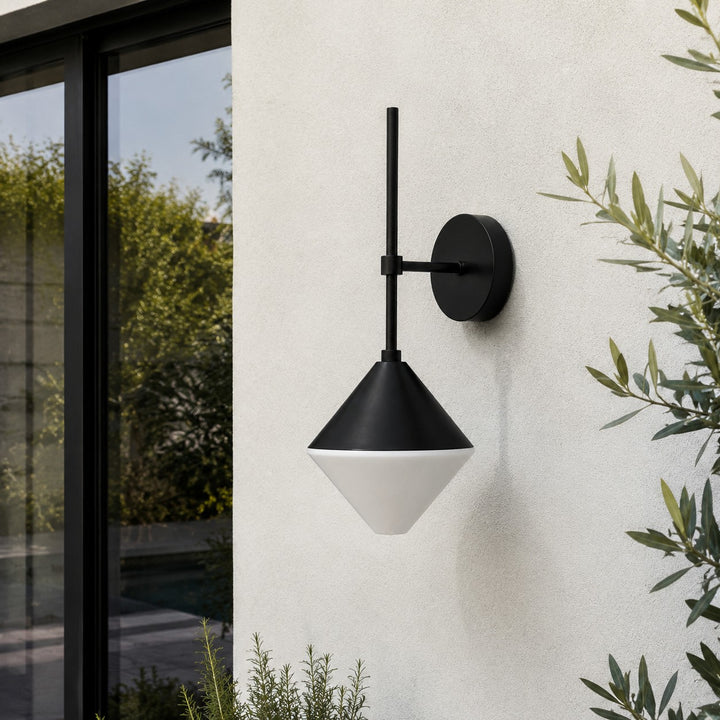 black and white outdoor wall sconce mounted on a garden exterior wall